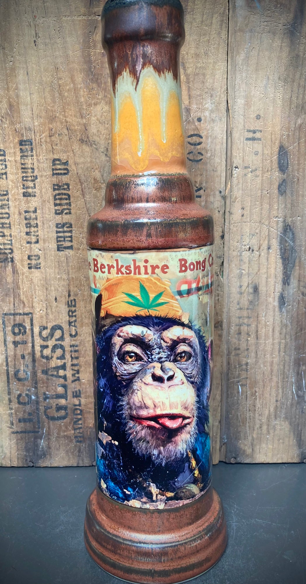 ceramic bong with chimp sticking out tongue antiqued copper glaze