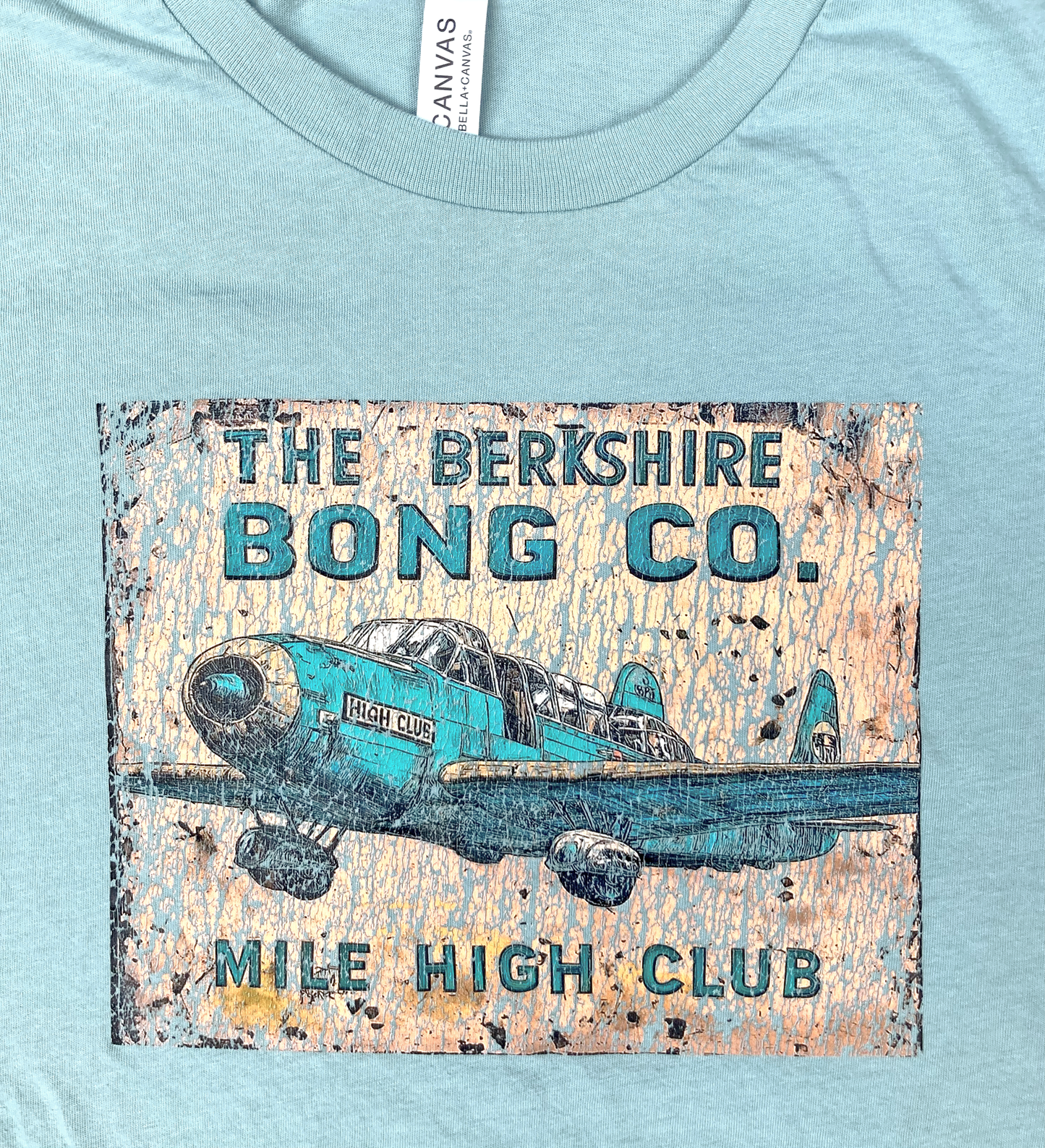 Mile High Club Vintage Airplane T-Shirt Distressed Comic Art on light blue tee with turquoise plane and Berkshire Bong Co logo