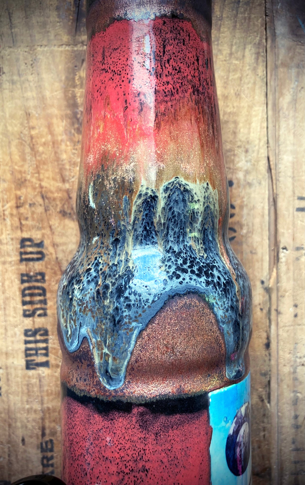 Handmade ceramic bong showing prehistoric creatures in a vibrant glaze palette.