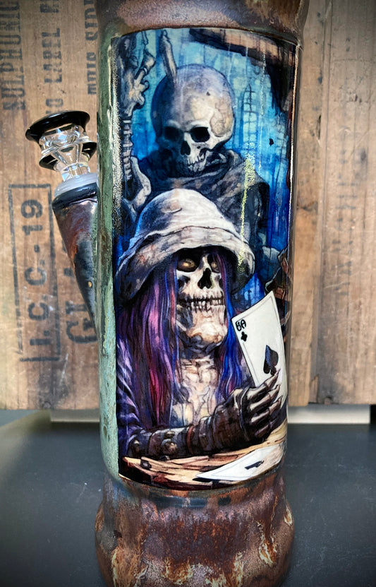 Handmade bong showing skeletons and ace of spades in swamp-toned glaze.