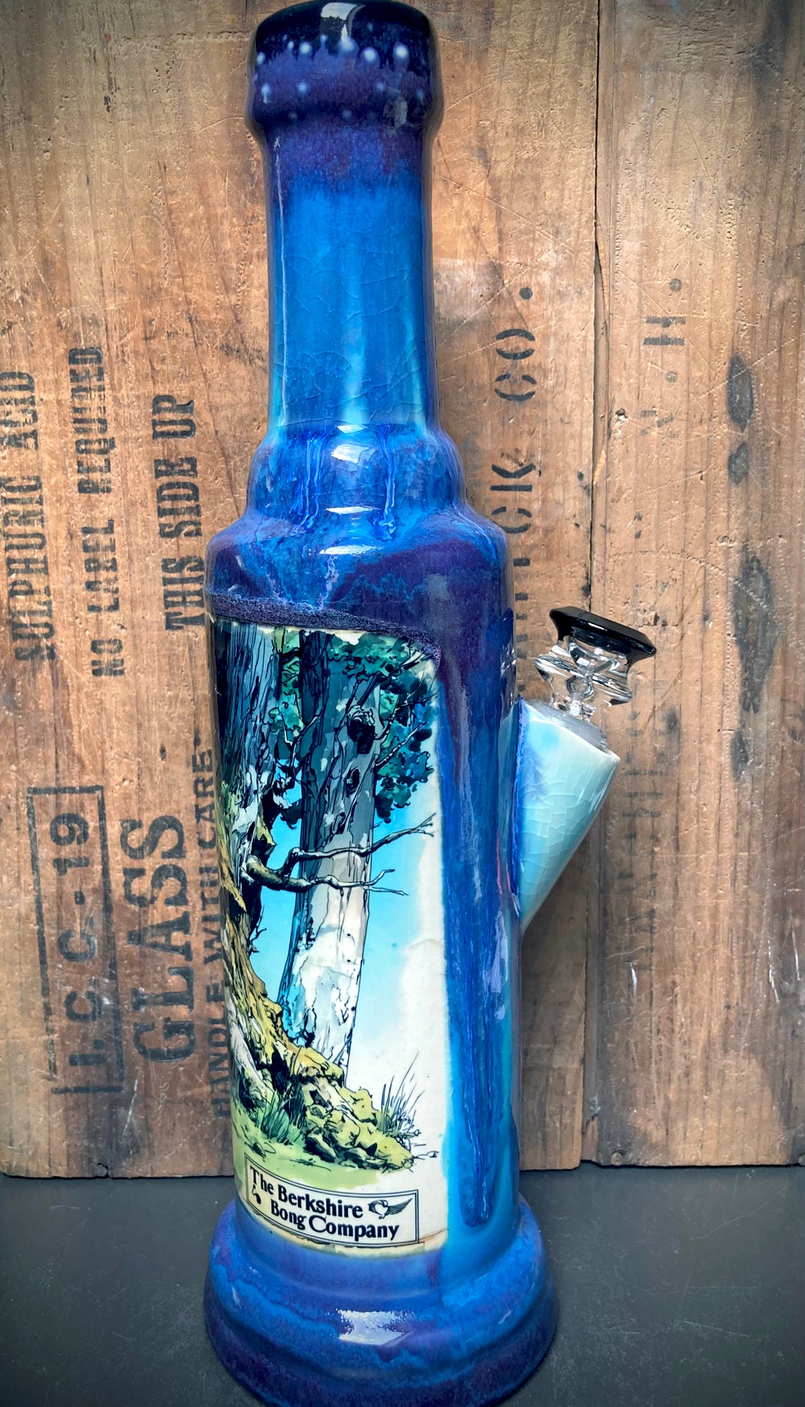 Artistic bong base with deep blue and amethyst glaze pooling.