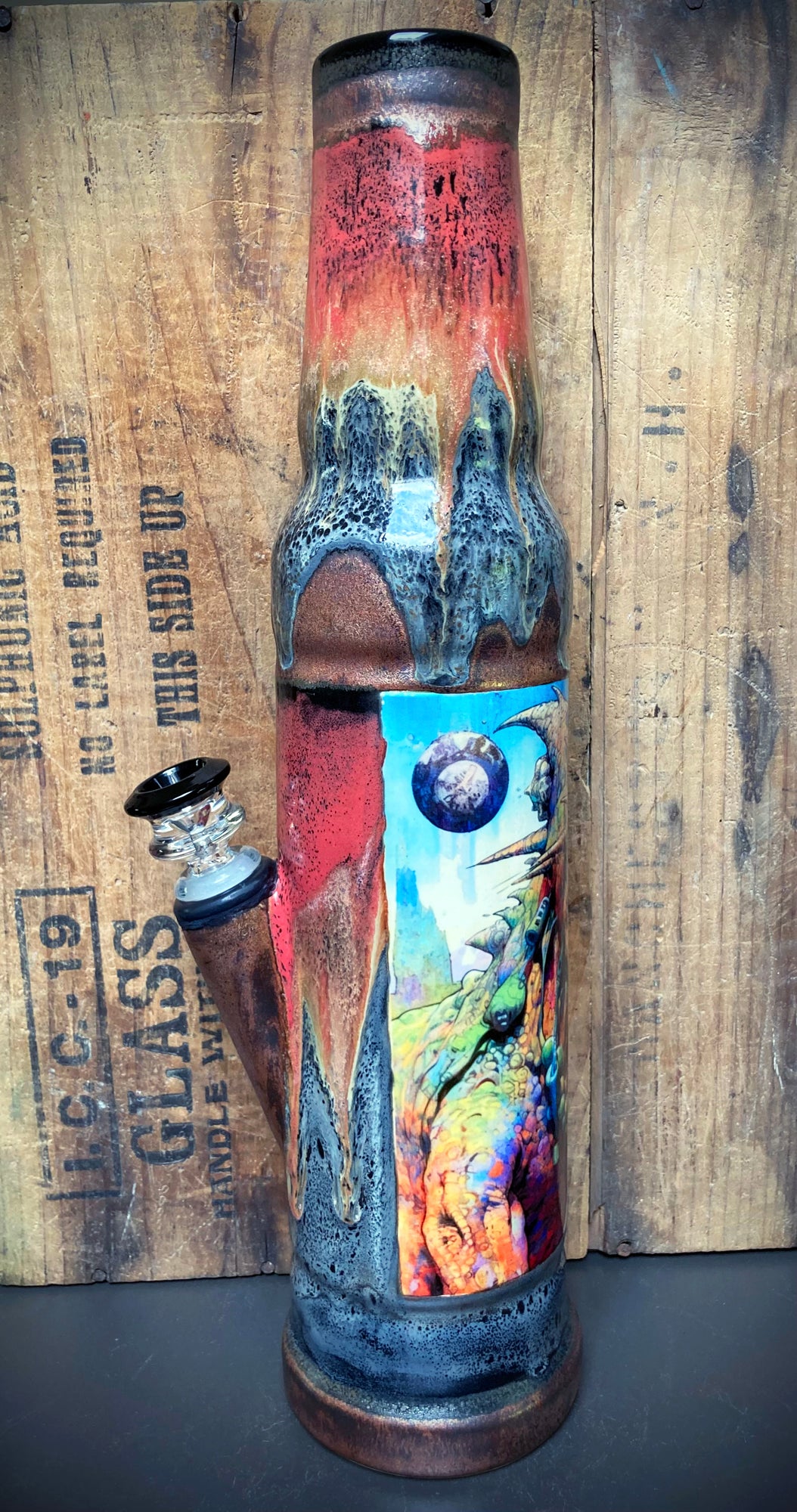 Ceramic bong with glowing volcano glaze and dinosaur jungle artwork.