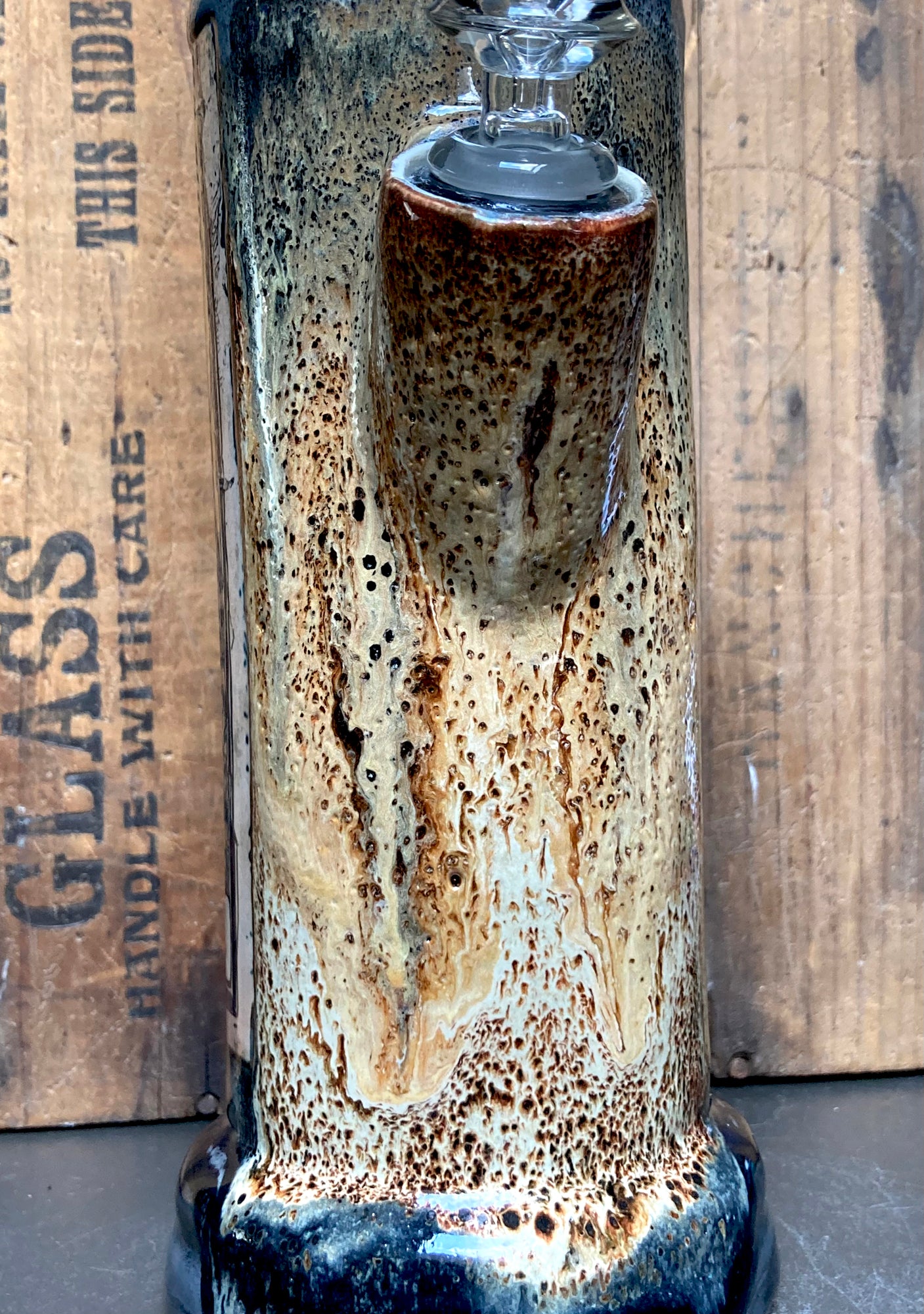 Macro of the ceramic glaze lava drips rust and cream flowing over speckled grey