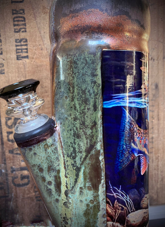 Fishing themed ceramic bong with trout design and forest river backdrop.