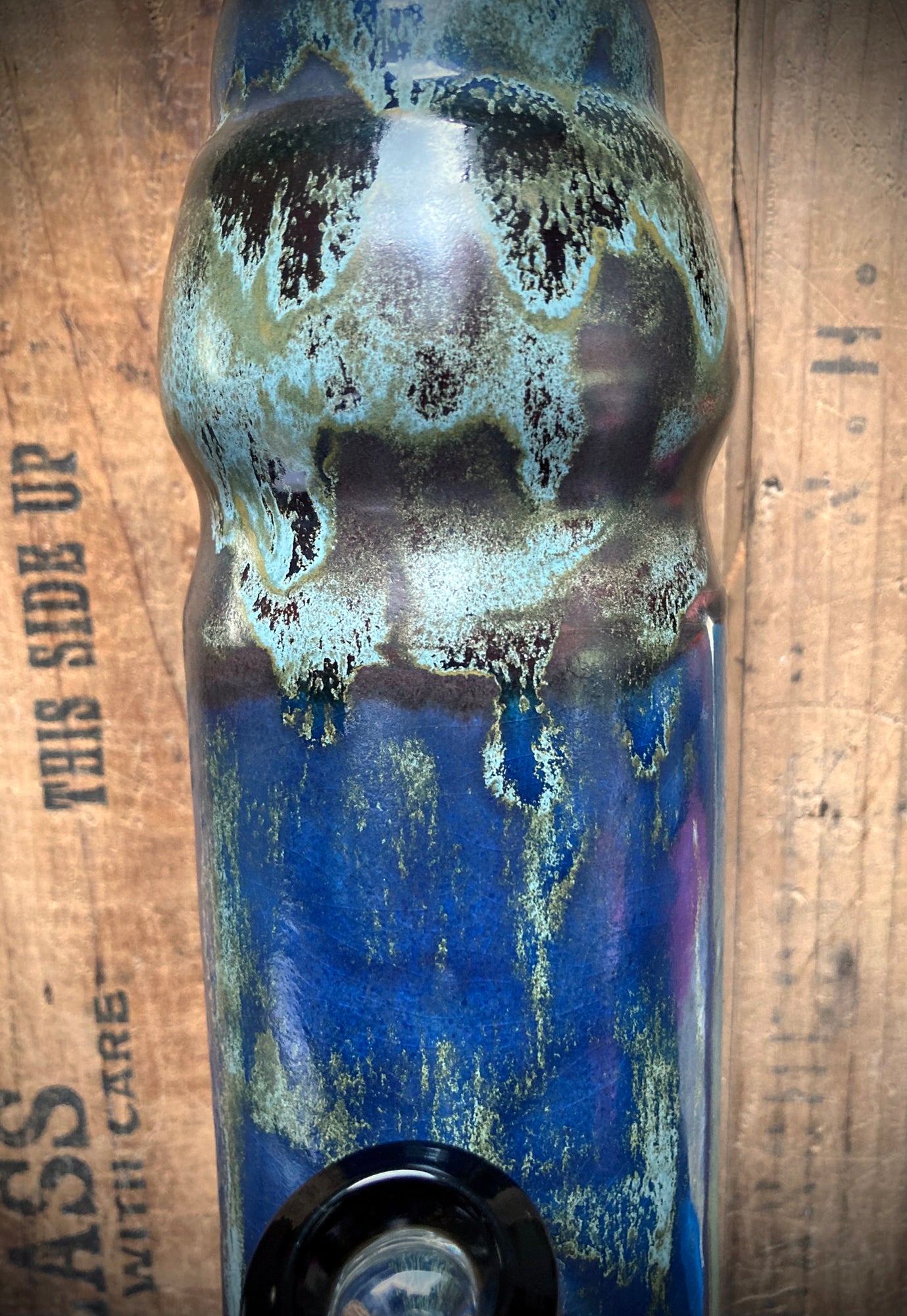 Cosmic-themed ceramic bong with tribal design in reflective glazes.
