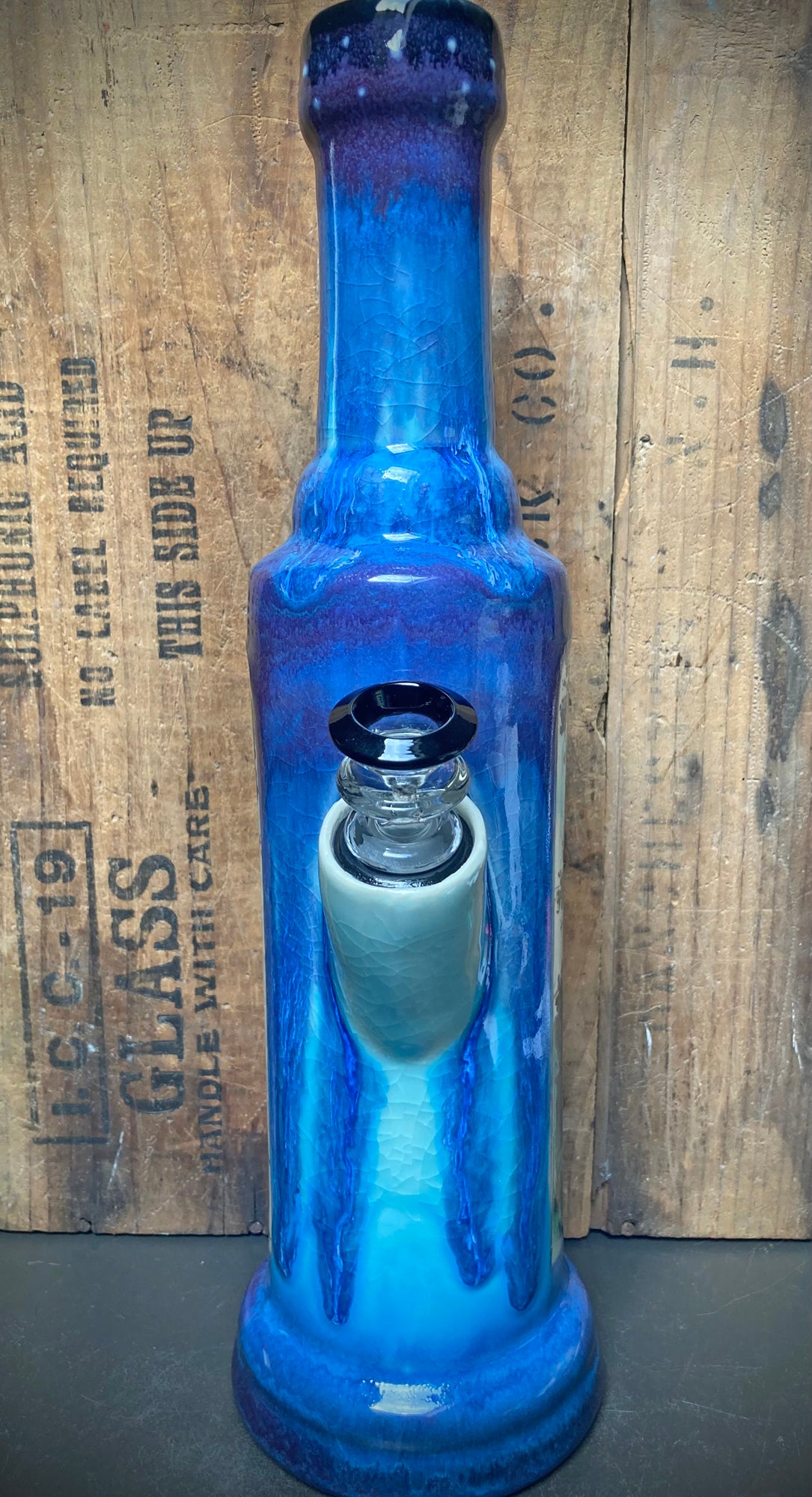 Handmade ceramic bong with glossy blue and purple glaze, light blue crackle effects.