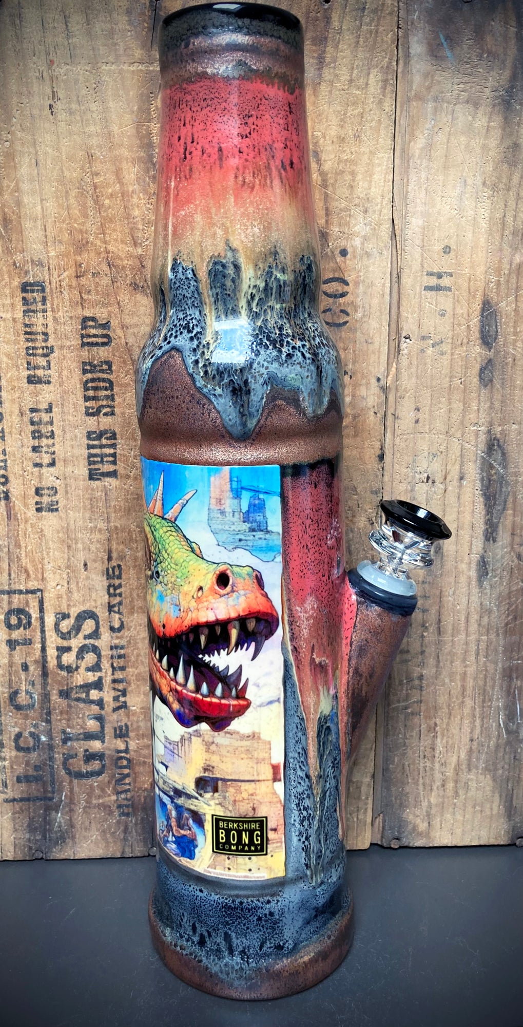 Ceramic bong featuring dinosaurs in a glowing volcanic jungle with red and orange glazes.