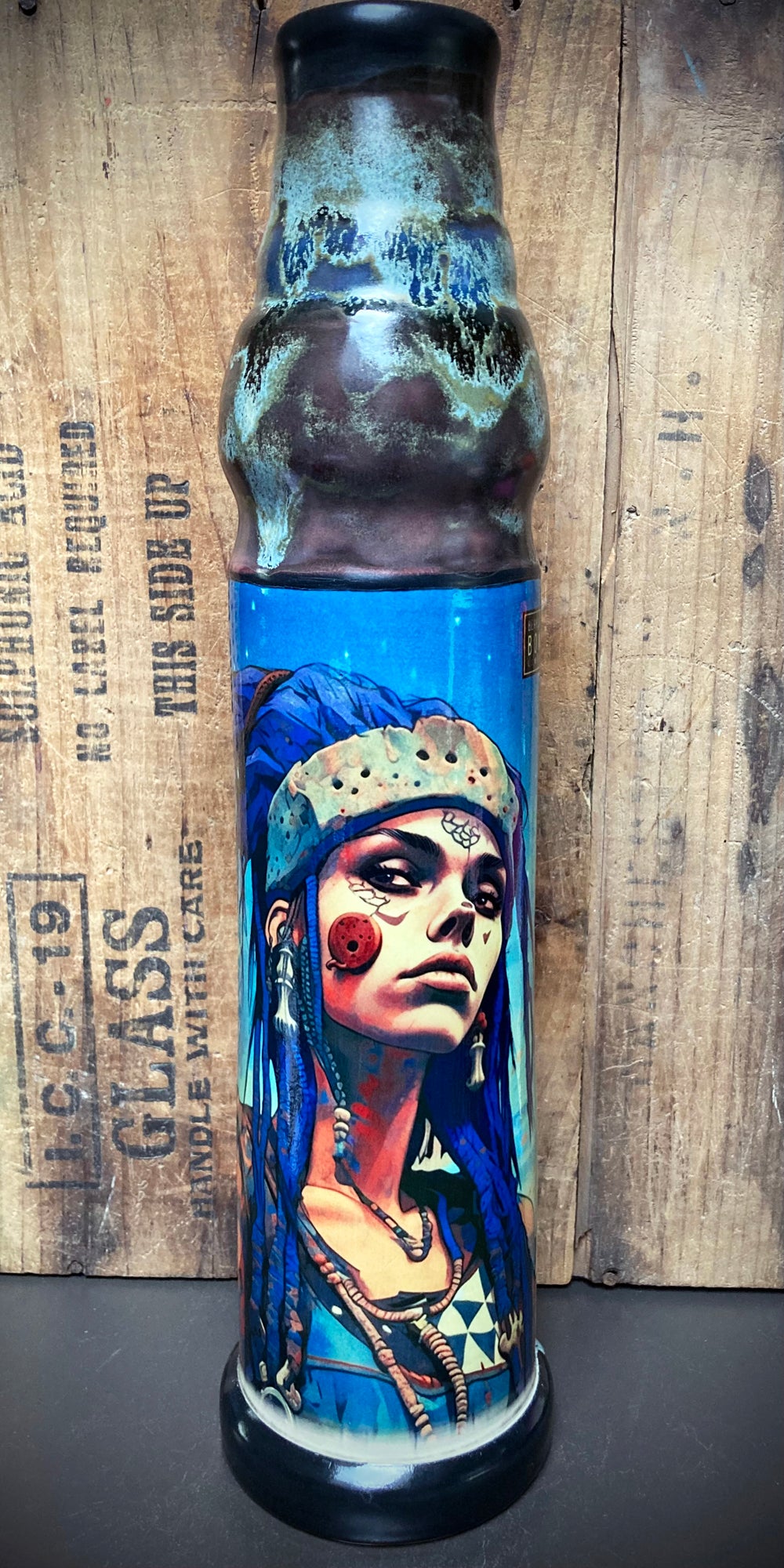 Star seed figure design on ceramic bong with metallic blue and silver glazes.