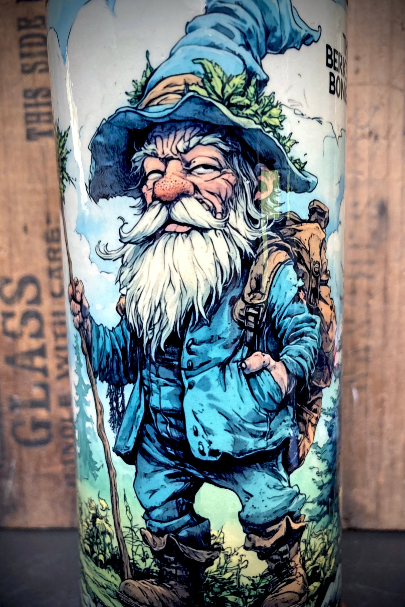 Close up of gnome’s face with wide brimmed hat and green leaf detail.