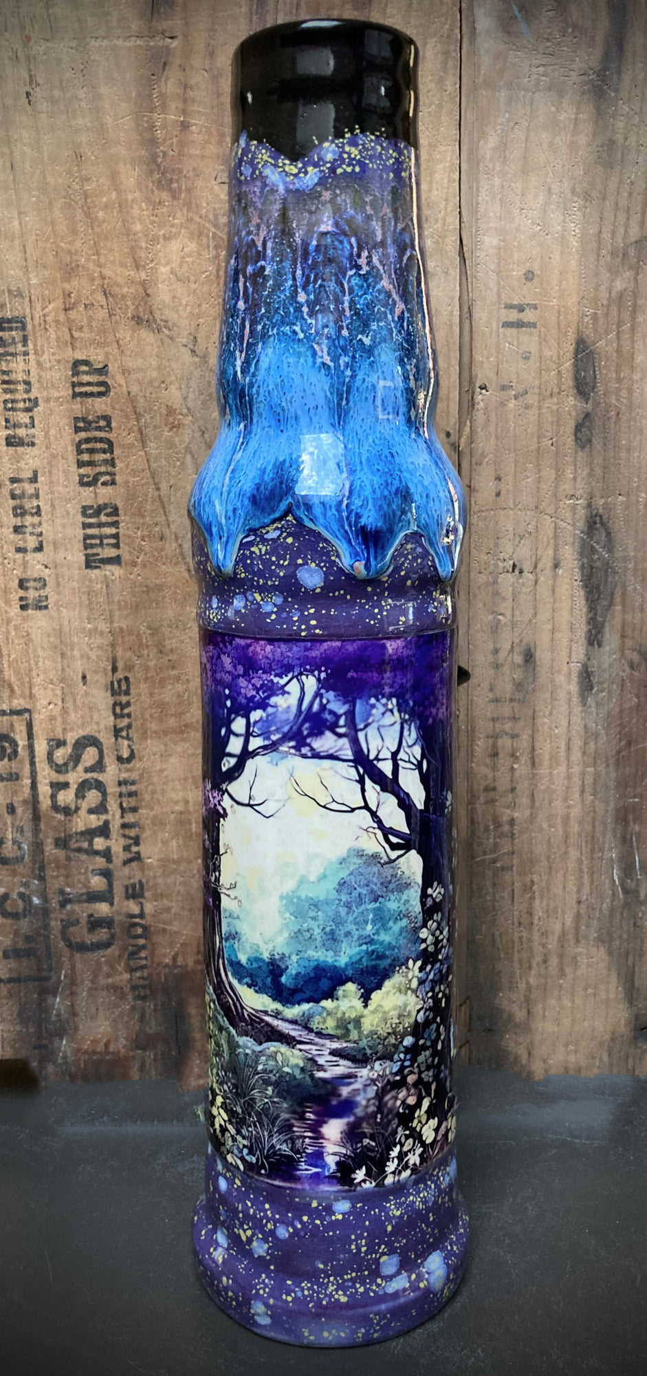 Ceramic bong showing a wooded trail surrounded by tall trees.