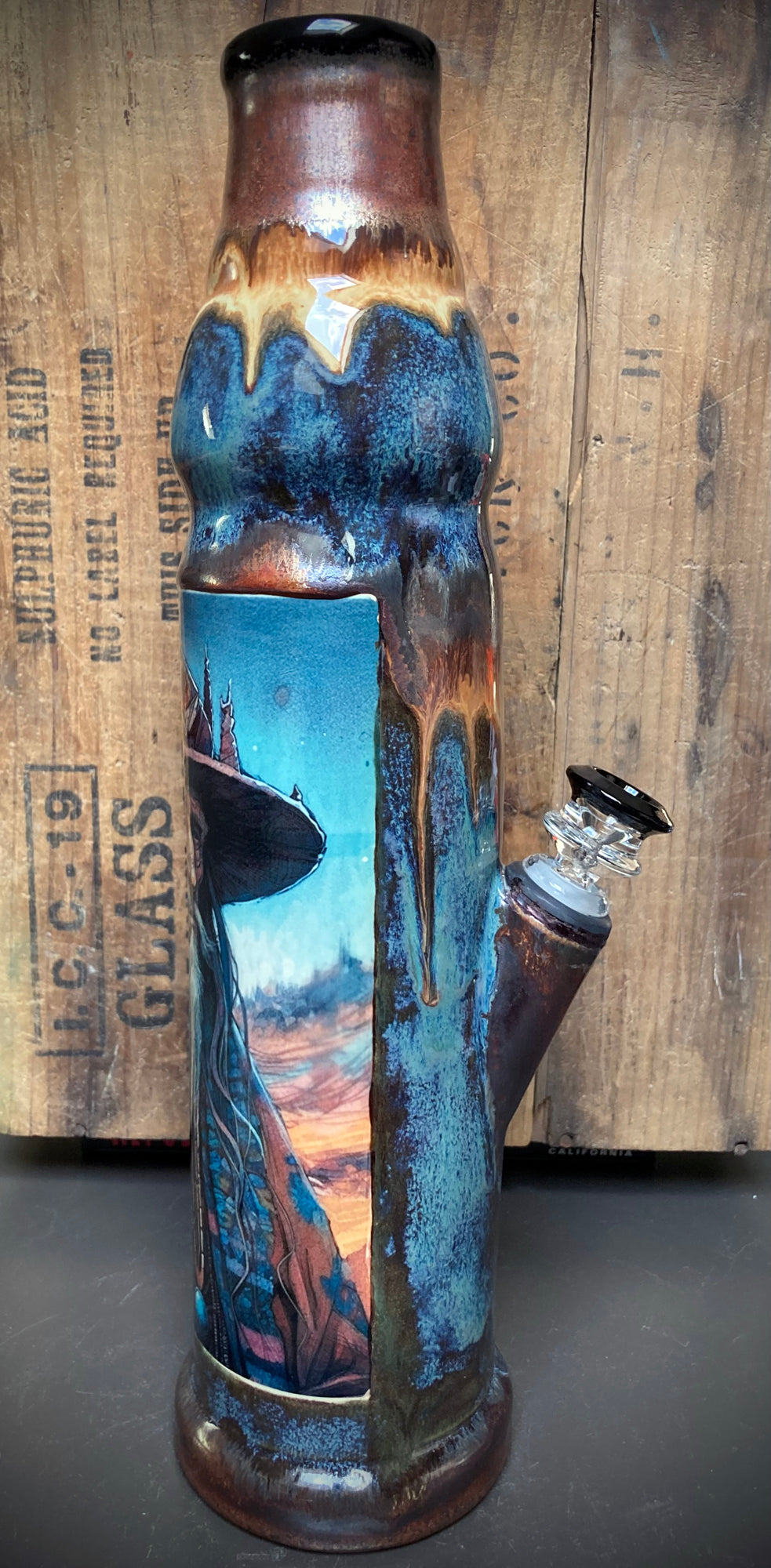 Ceramic bong with mystical timekeeper art in copper, rust, and blue glazes.