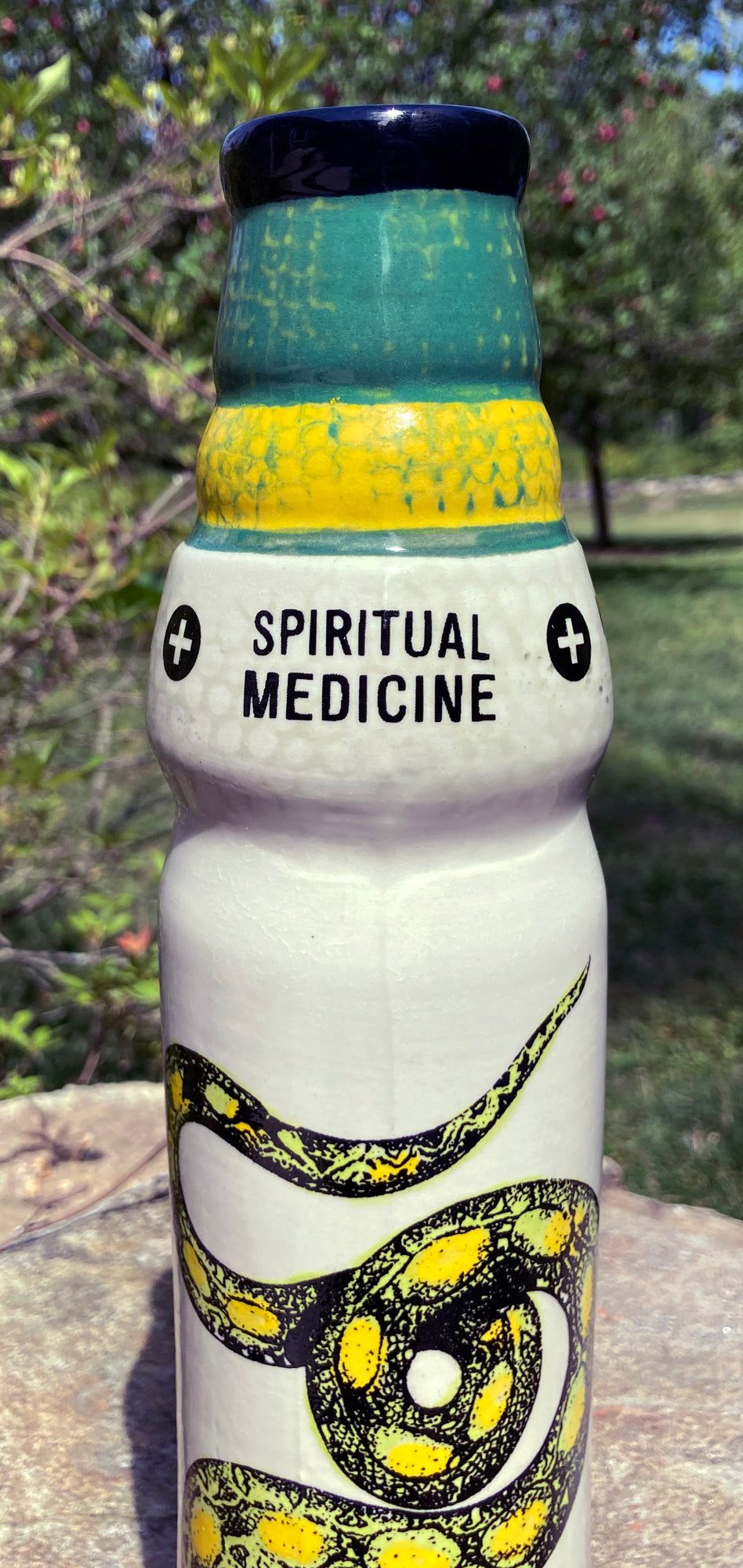 Ceramic snake bong featuring intricate yellow snake design and Spiritual Medicine text