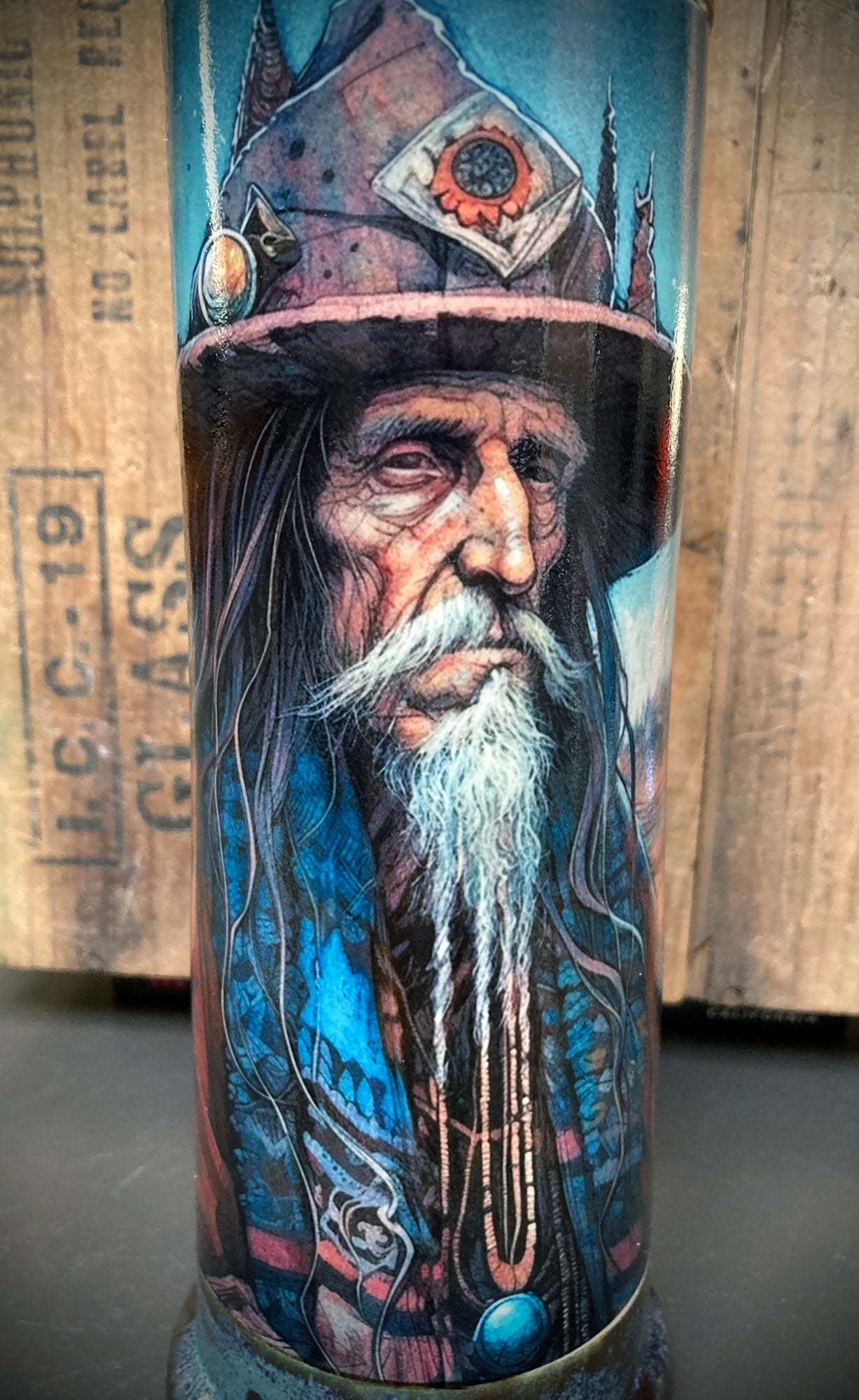 Wise old man design on ceramic bong with rustic blue and metallic highlights.