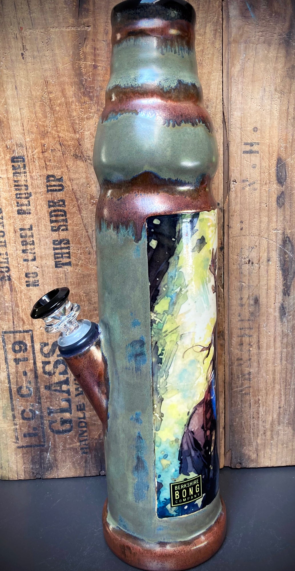 Forest king with flowing beard illustrated on ceramic bong in woodland setting.