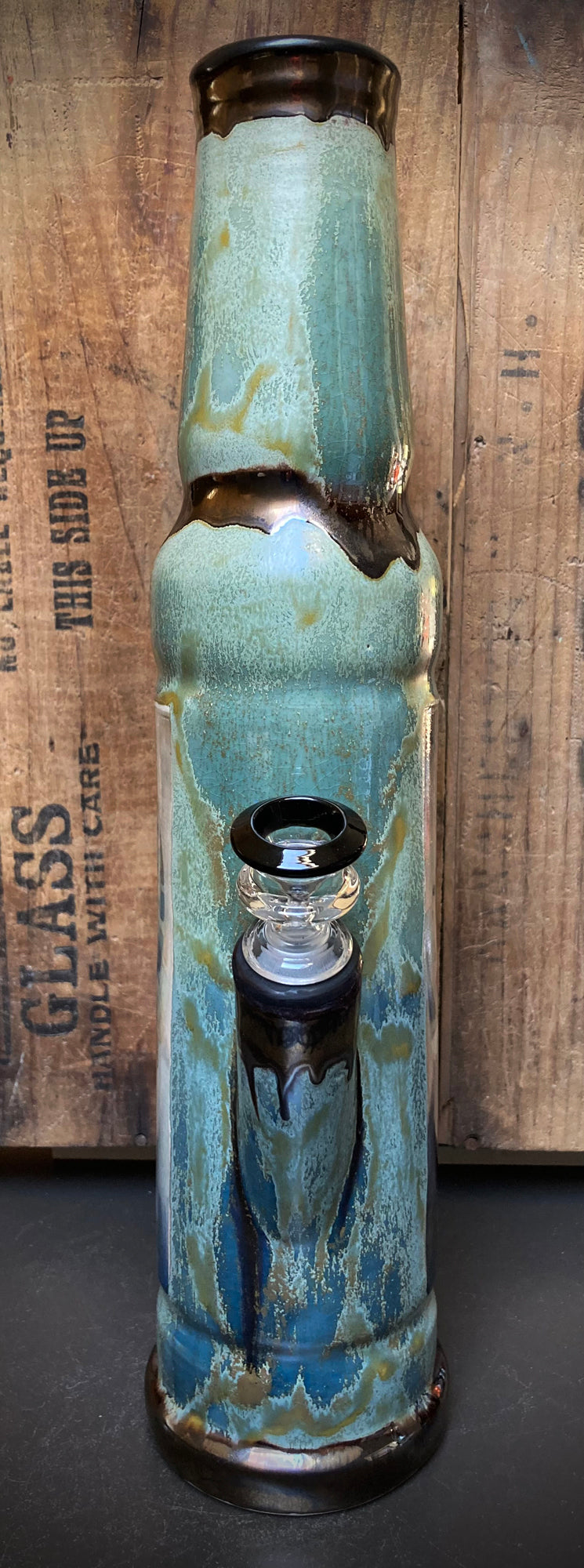 Ceramic bong showing River Queen with earthy green and golden hues.