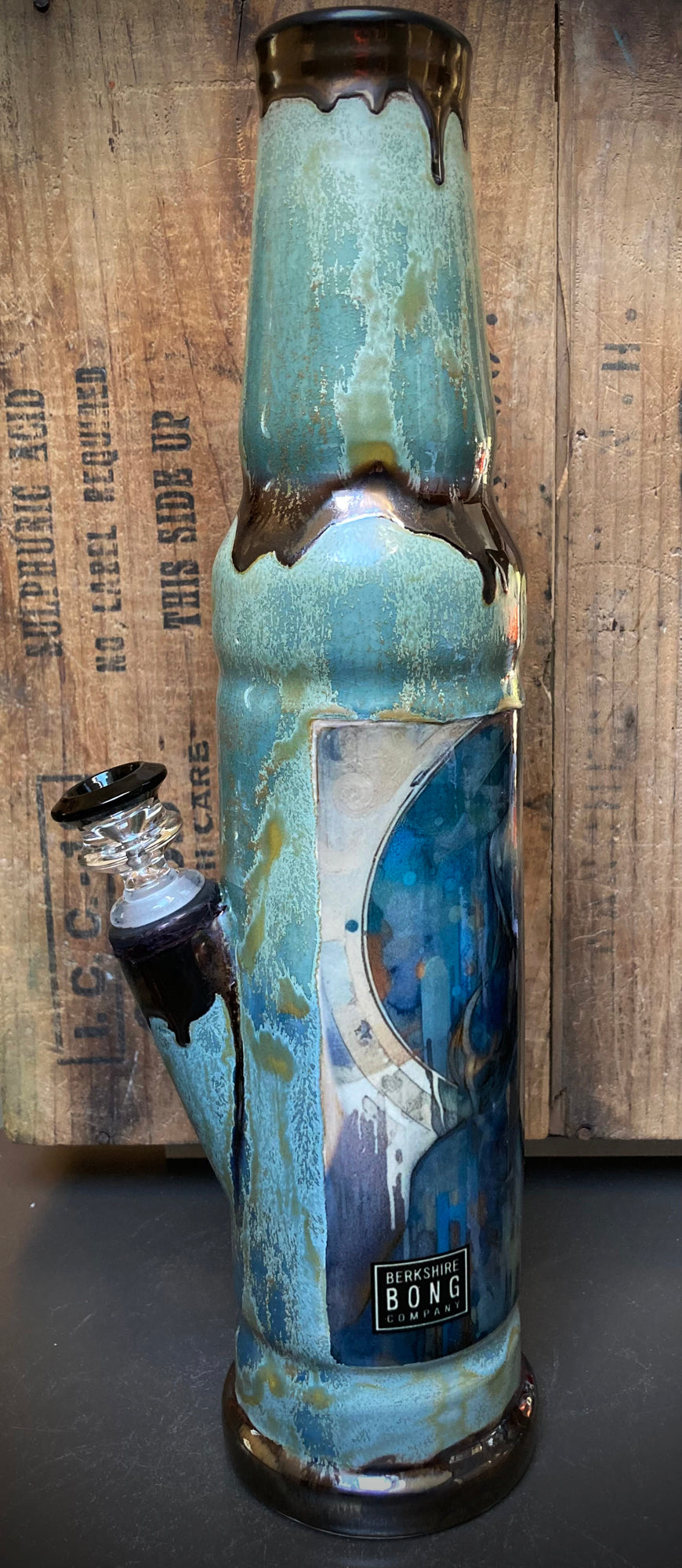 Ceramic bong with divine feminine river spirit in glowing green and gold.