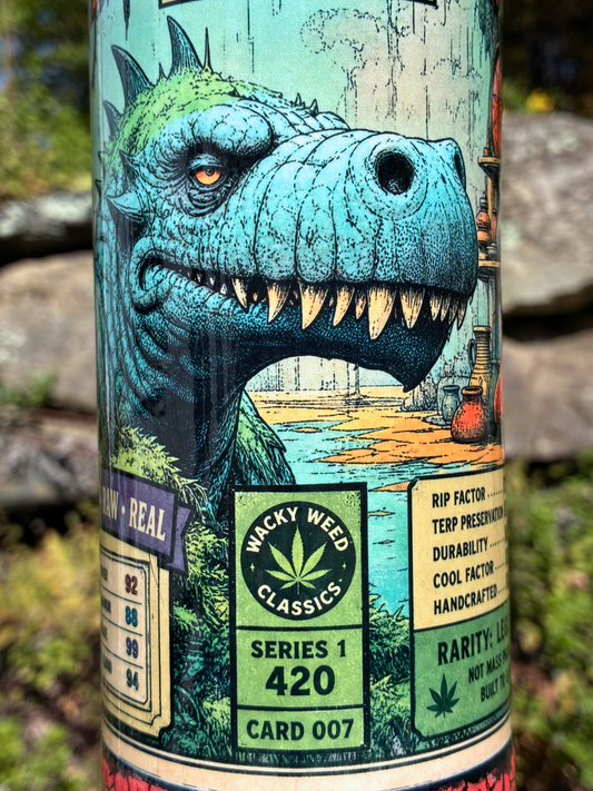 Monster Rips handmade ceramic bong featuring blue-green dinosaur collector-card artwork, deep red crackle glaze and glossy black accents.