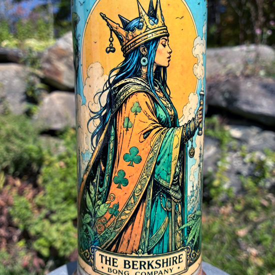 Queen of Clubs handmade ceramic bong featuring crowned queen playing-card artwork, softly flowing blue and lavender glaze, and copper-brown accents.