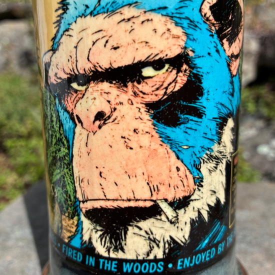 Stoned Strong handmade ceramic bong featuring blue chimp comic artwork, mossy green glaze, antique copper accents and a neon yellow-green crackle stripe.