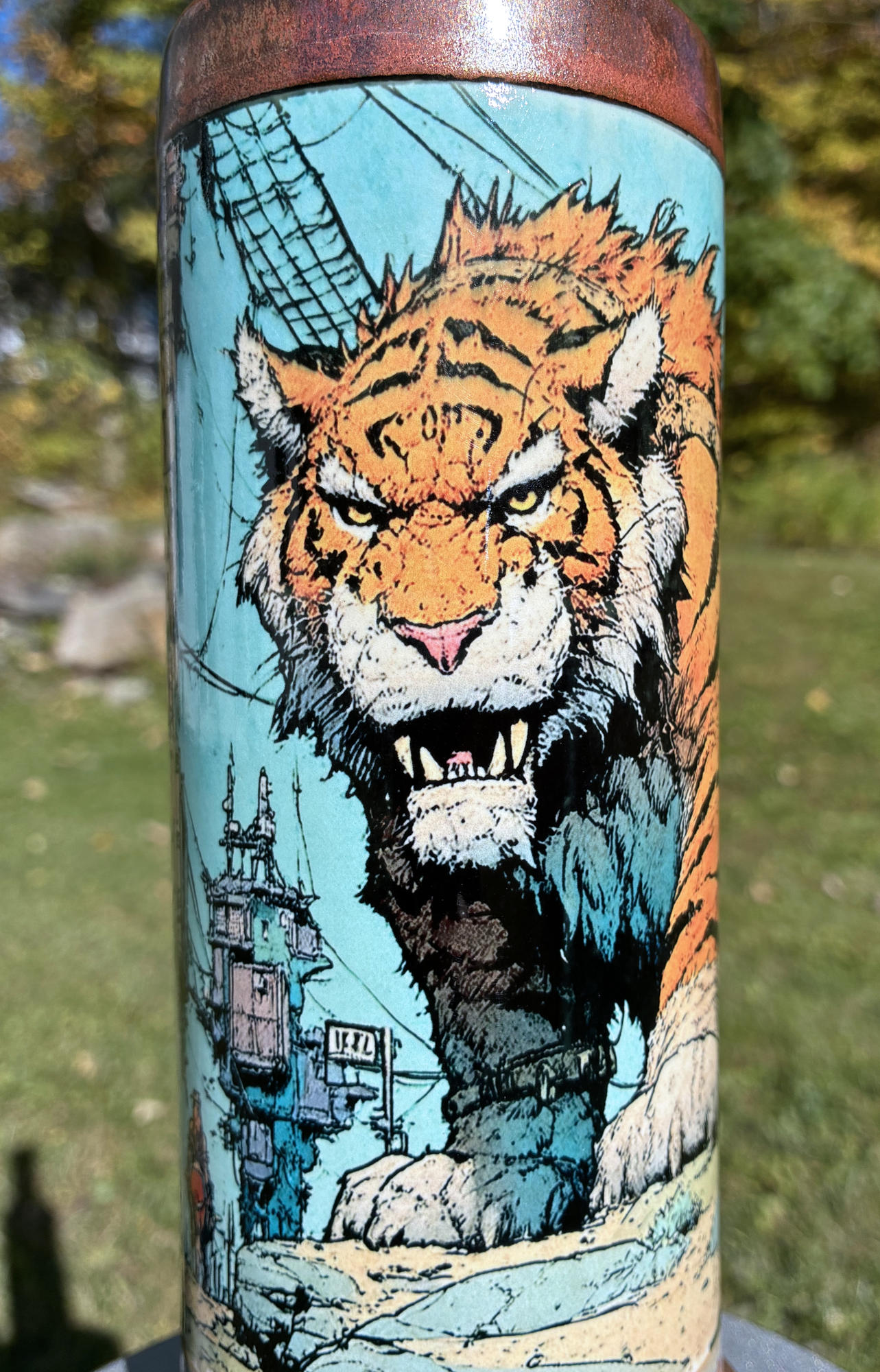 Inner Strength handmade ceramic tiger bong featuring orange tiger artwork, flowing teal and creamy yellow glaze, and copper-brown accents.