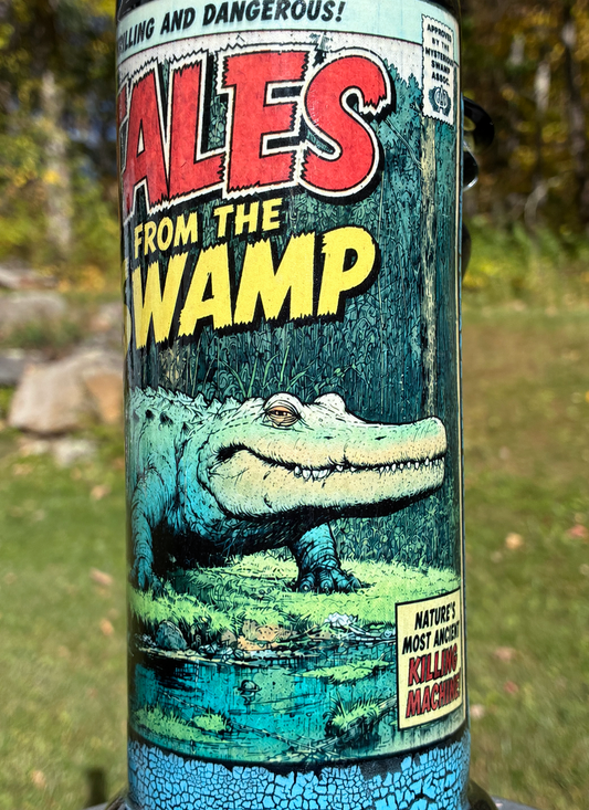 Tales from the Swamp handmade ceramic alligator bong featuring vintage comic-book artwork, blue crackle glaze and glossy black accents.