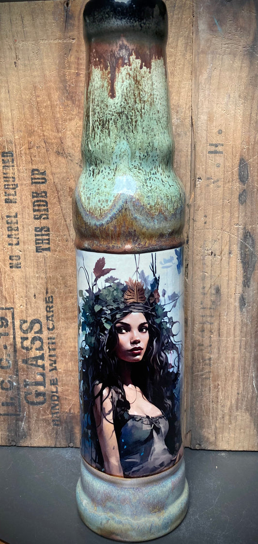 Crowned forest spirit woman featured on ceramic bong with rustic glazes.